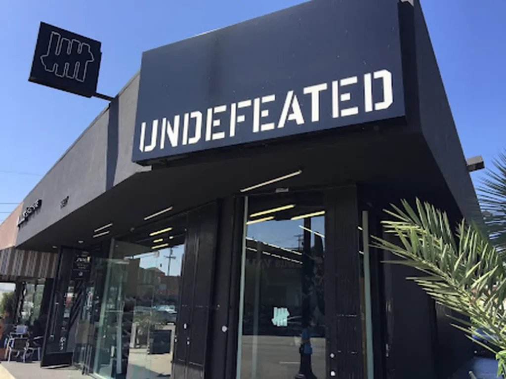 7. Undefeated Undefeated é uma varejista de Los Angeles que combina streetwear com tênis premium, conhecida por colaborações com Nike, Jordan e Adidas.