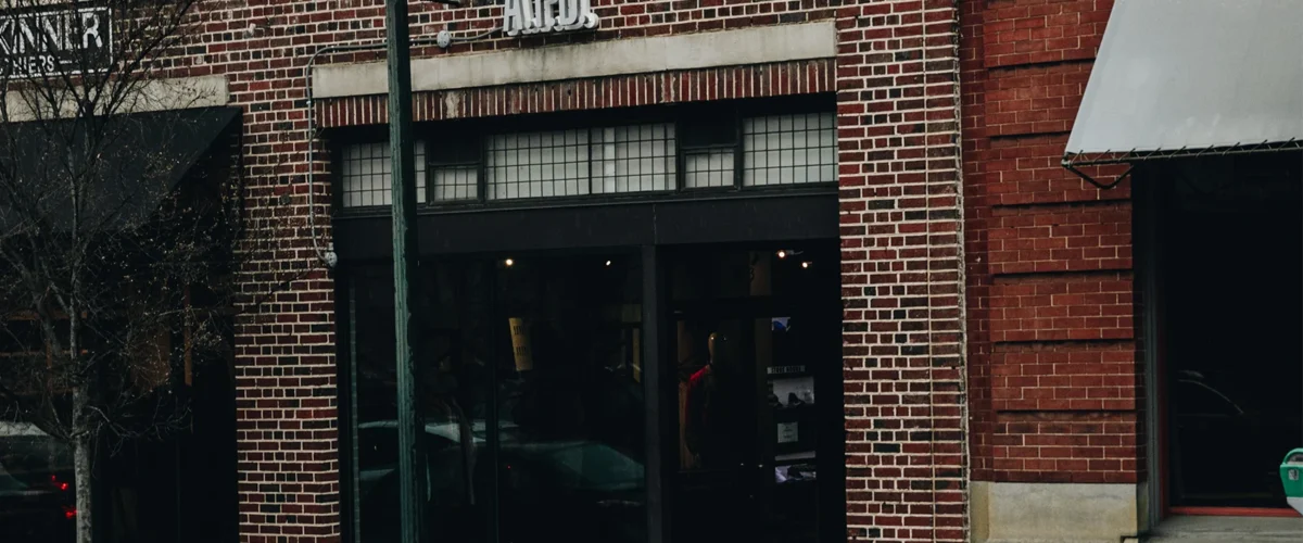 Exterior de APB Store en Columbia, con una entrada de vidrio retranqueada en una fachada de ladrillo.