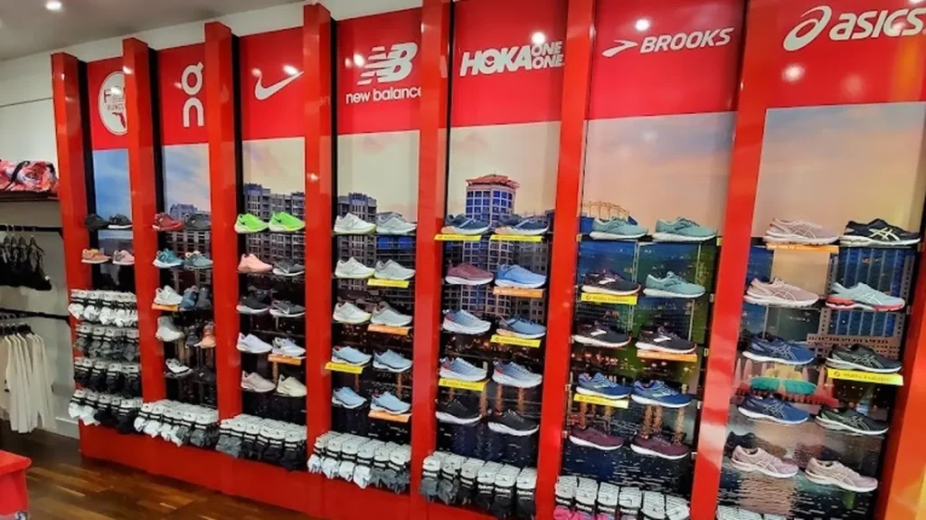 Shelves packed with running shoes from brands like New Balance, Hoka, Asics, and Nike at Fit2Run in Orlando