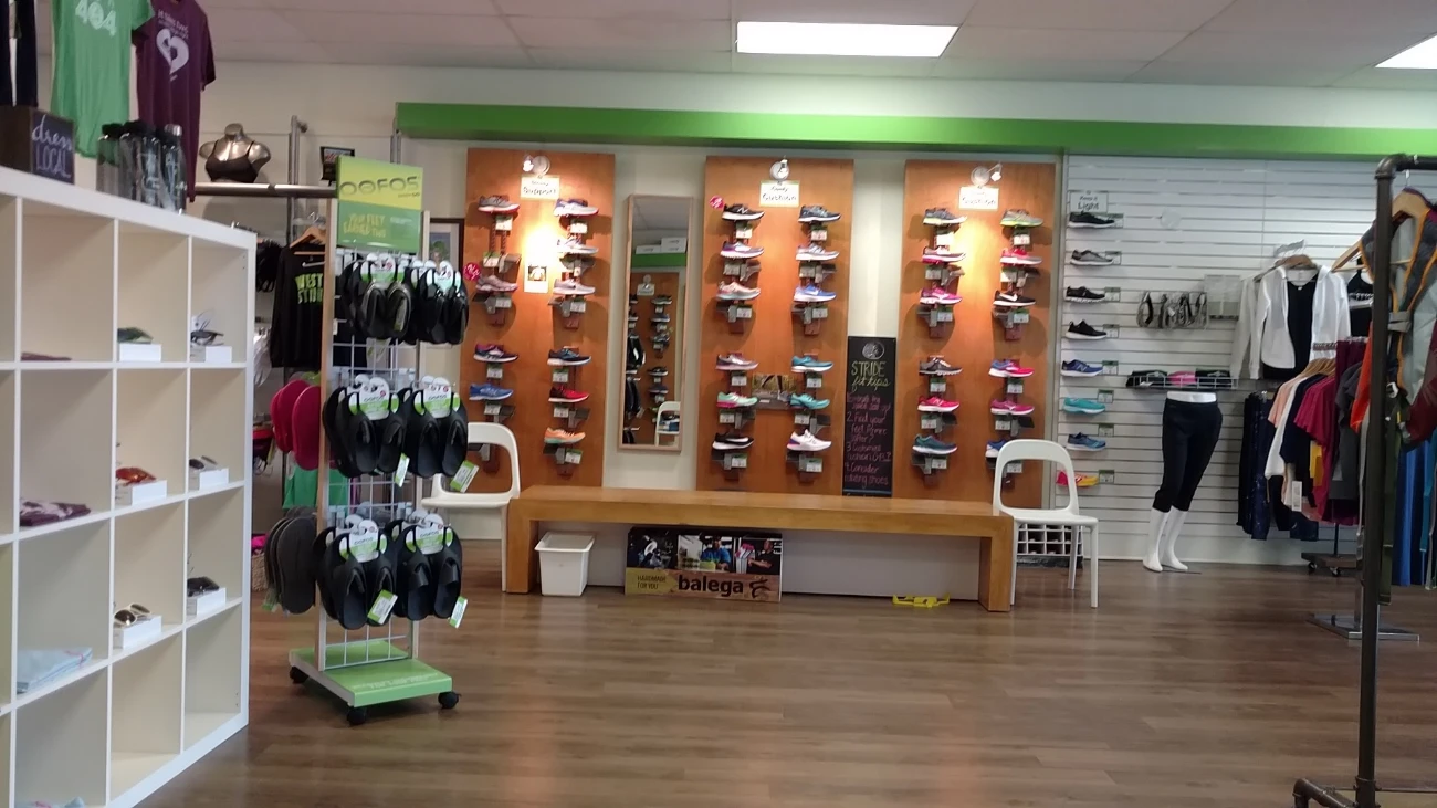 Running-shoe display panels beside a fitting bench and a sandal rack.