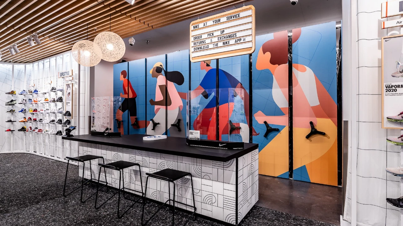 Nike service counter with black stools, sneaker walls and colorful illustrated runners.