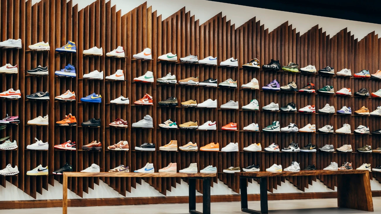 Sneaker display wall with vertical wooden fins and two wooden benches.