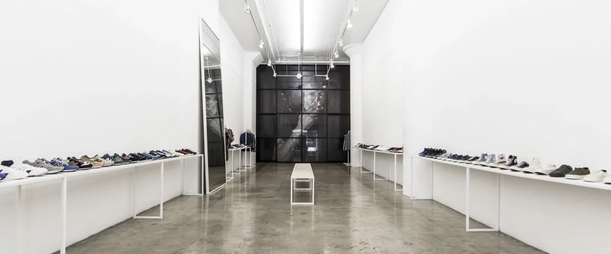 Minimalist Blends interior in Los Angeles, with sneakers on low white display counters along both walls.