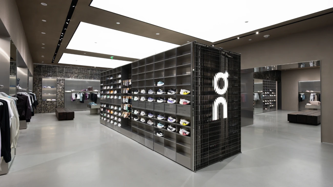 On store interior with a black central footwear wall and open display areas