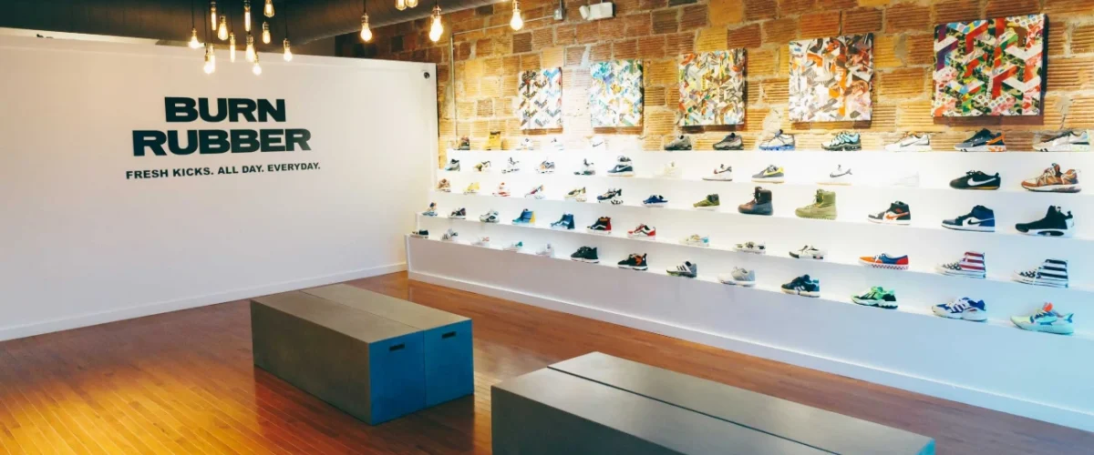 Sneaker displays on curved white shelves in the basement of Dover Street Market New York.