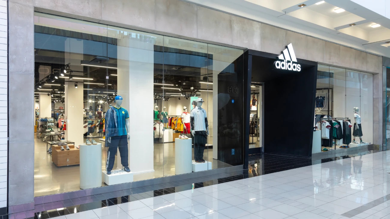 Glass-fronted adidas store entrance with clothing displays and mannequins