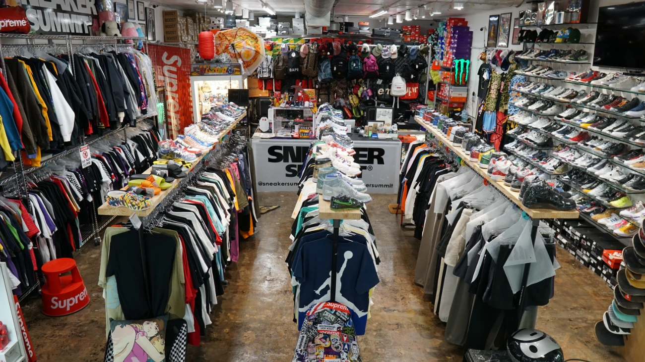 Long sneaker-store aisle lined with shoes, clothing and accessories