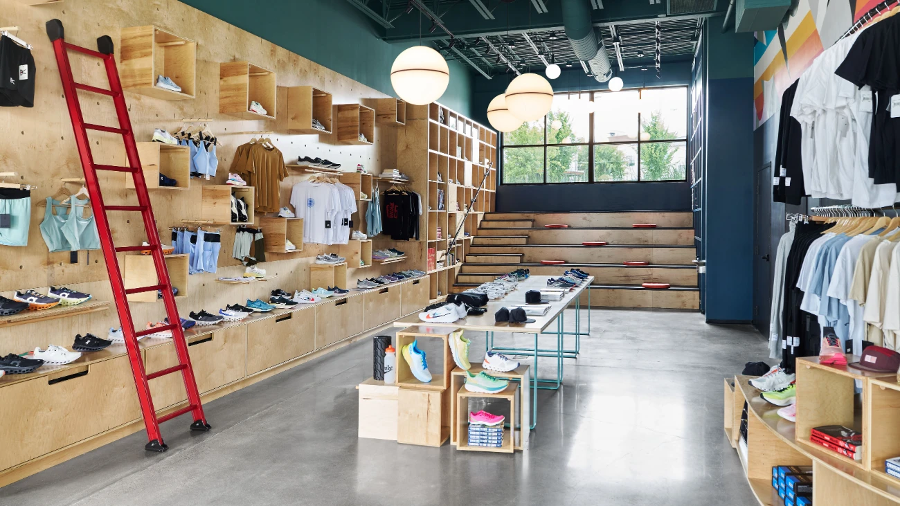 Running-store interior with wooden shoe displays and a red ladder