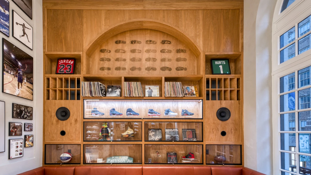 Wood-paneled store display with sneakers, records and framed basketball and football jerseys.
