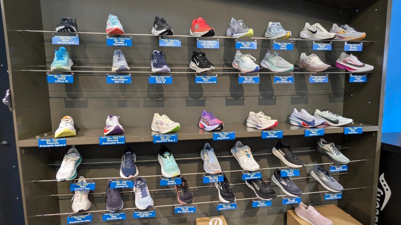 Running shoes on a dark wall display with blue model labels.