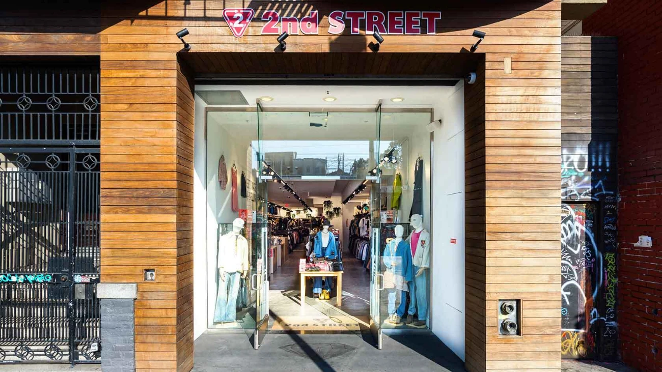 2nd Street storefront with a wood-clad entrance and clothing visible inside.