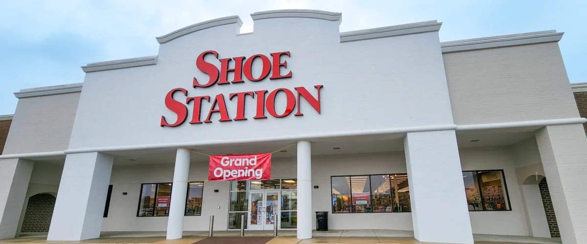 Shoe Station exterior at Brook Highland Plaza, with a red store sign above the covered entrance.