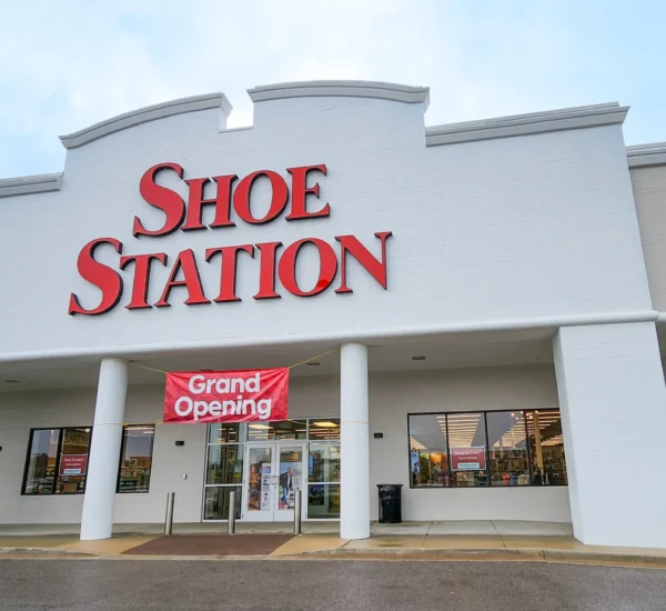 Shoe Station exterior at Brook Highland Plaza, with a red store sign above the covered entrance.