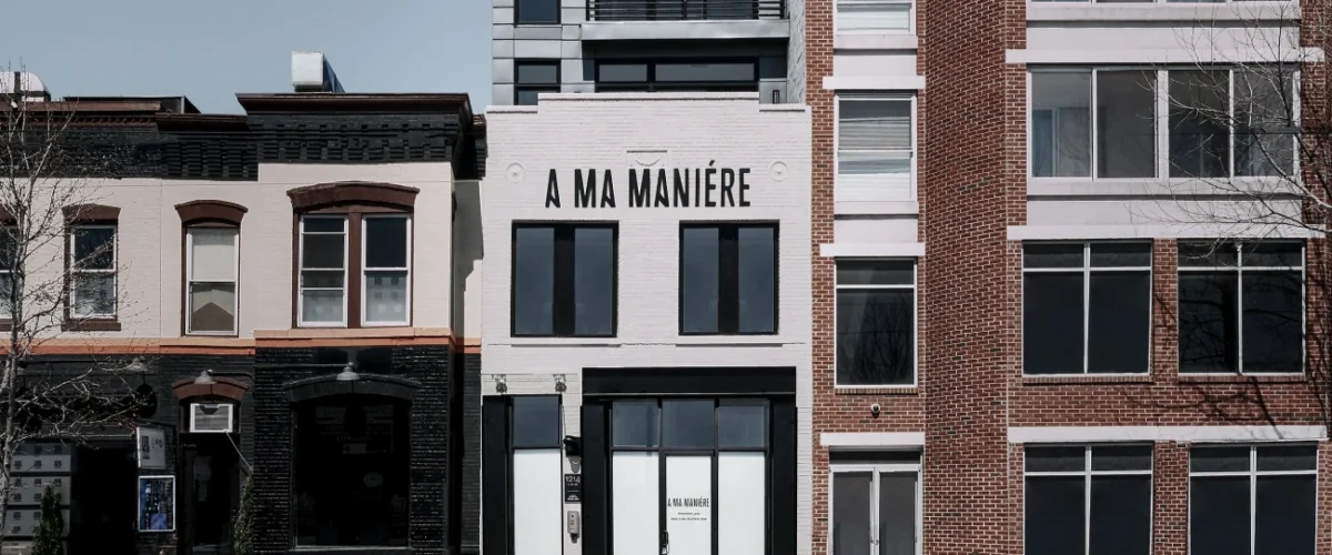 Social Status storefront in Charlotte, with its sign above the glass entrance and clothing visible in the windows.